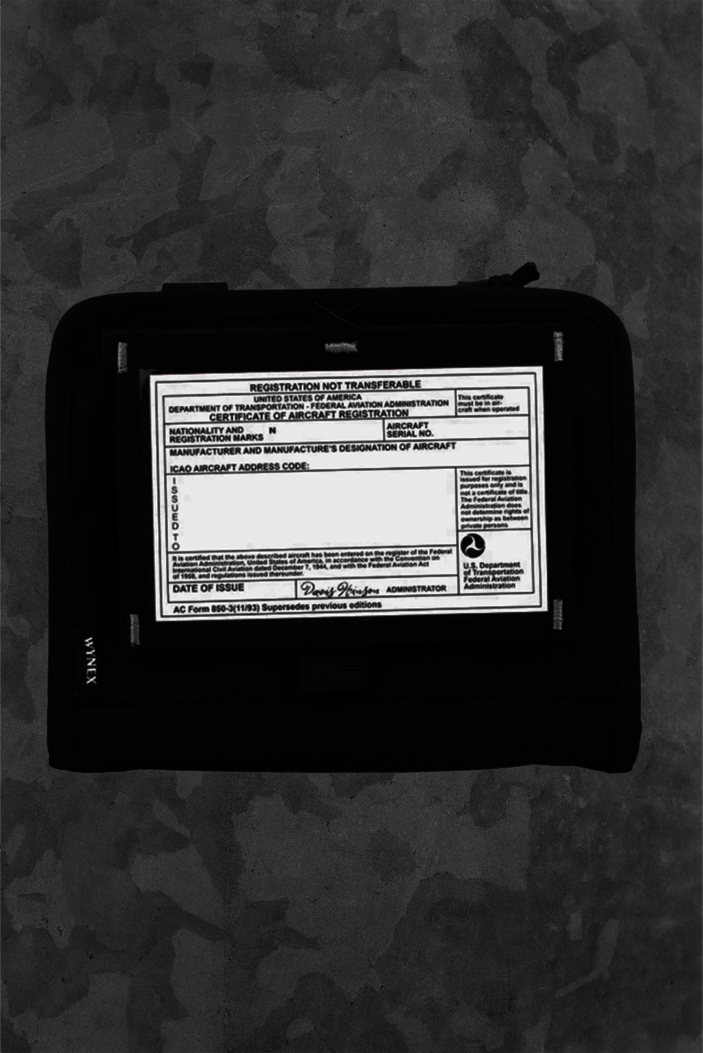 Black case with a label on a dark camouflage background