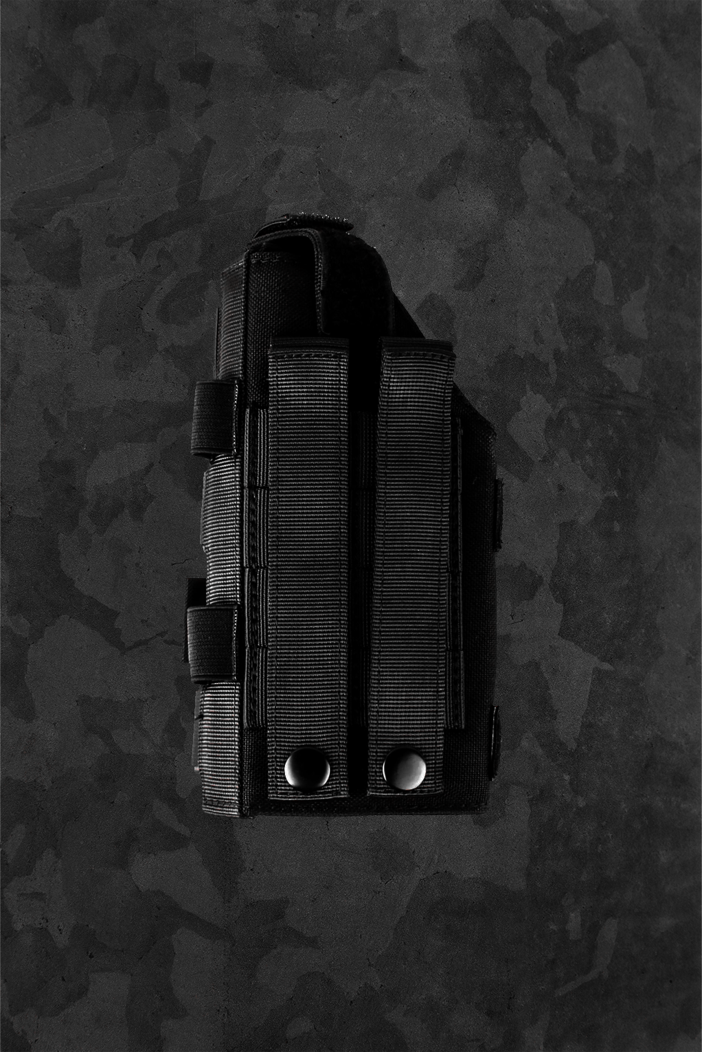 Black tactical gun holster on a camouflage-patterned background