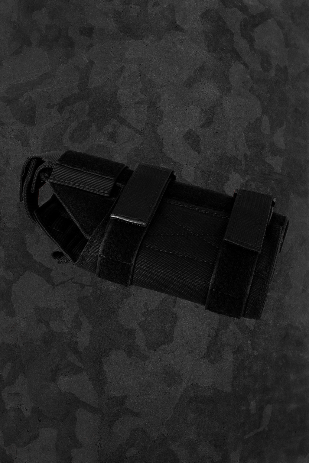 Black tactical gun holster on a camouflage-patterned background
