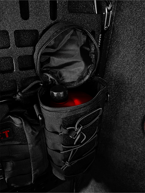 Dark interior of an aircraft with tactical bags and equipment attached to a Molle Rack.