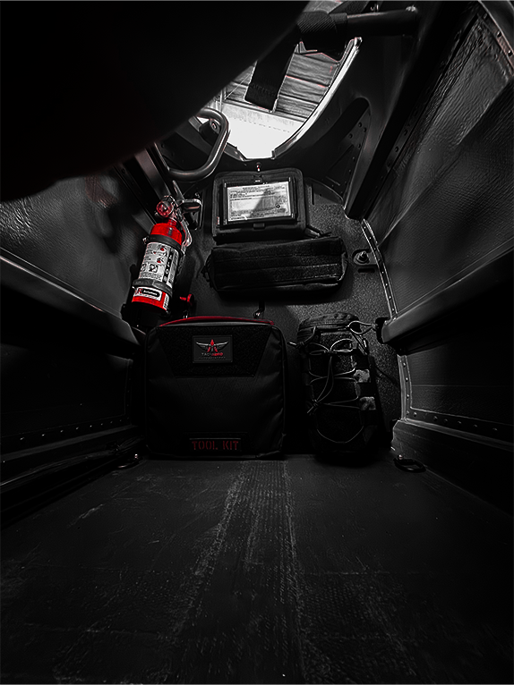 Tool kit and fire extinguisher attached to a Molle Rack in a vehicle's cargo area