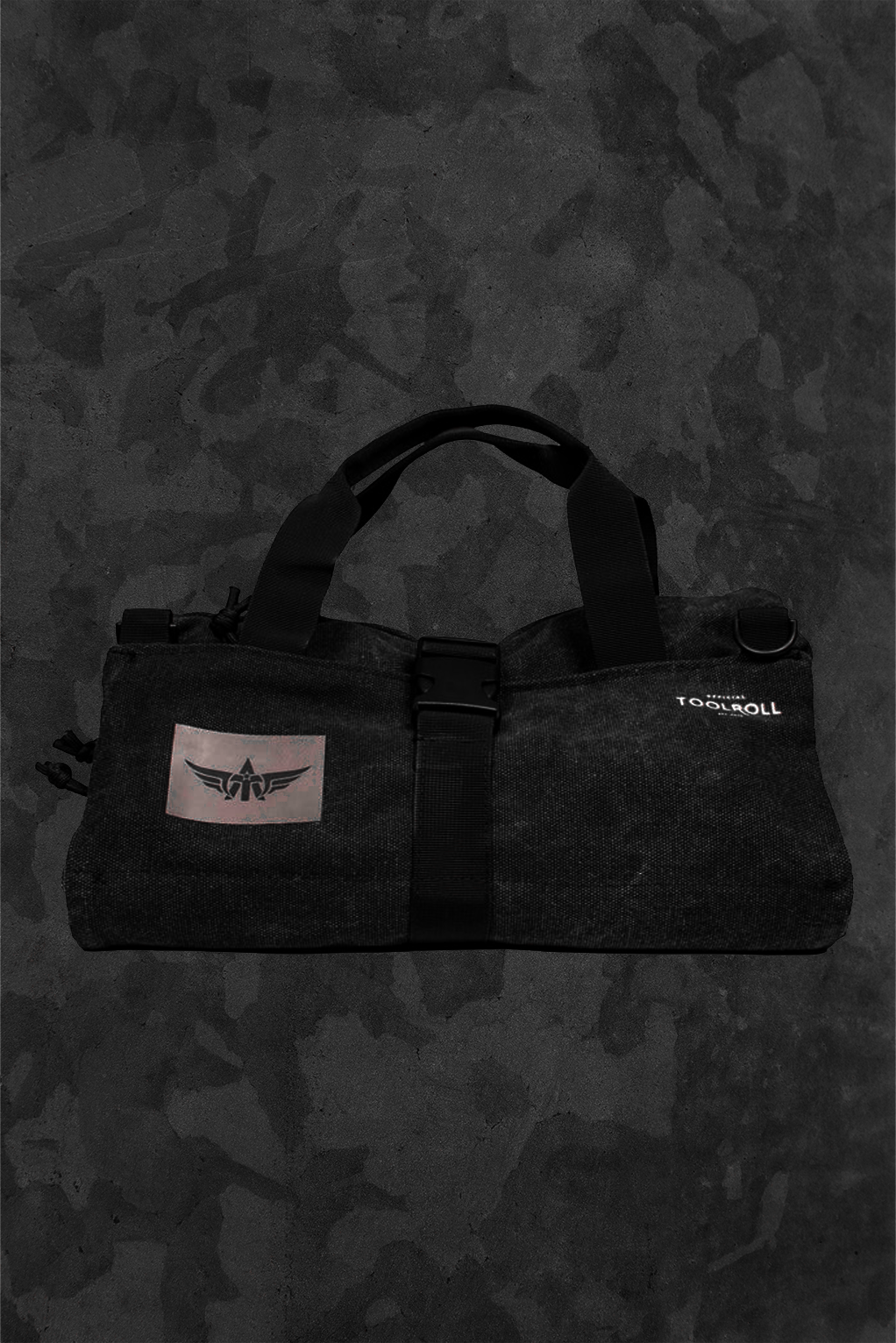 Black tie down kit bag with a TacAero logo on a dark camouflage background