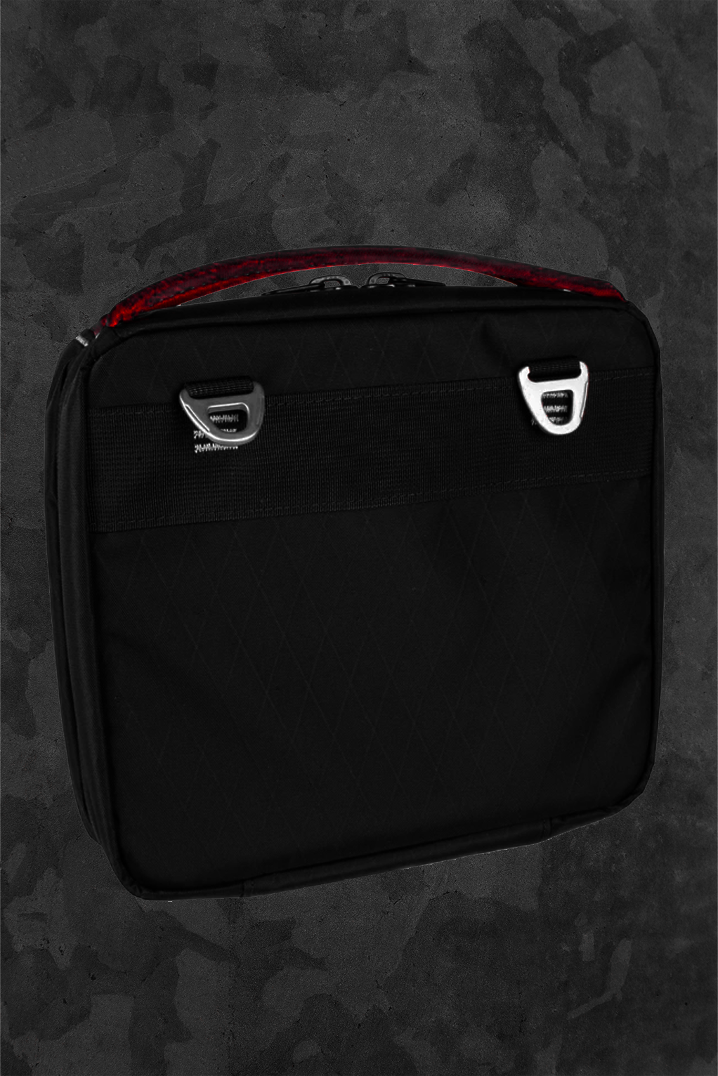 Black toolkit bag with red handle on a dark textured background